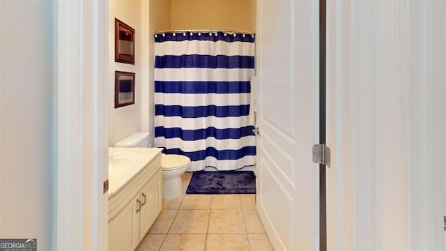 bathroom featuring curtained shower, tile patterned floors, vanity, and toilet