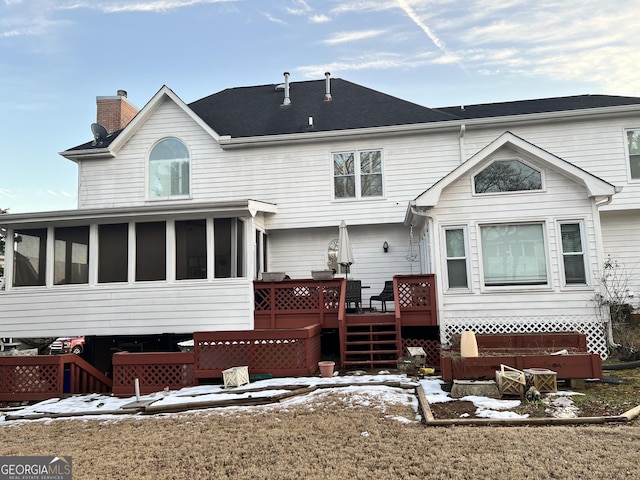 back of house featuring a wooden deck and a sunroom