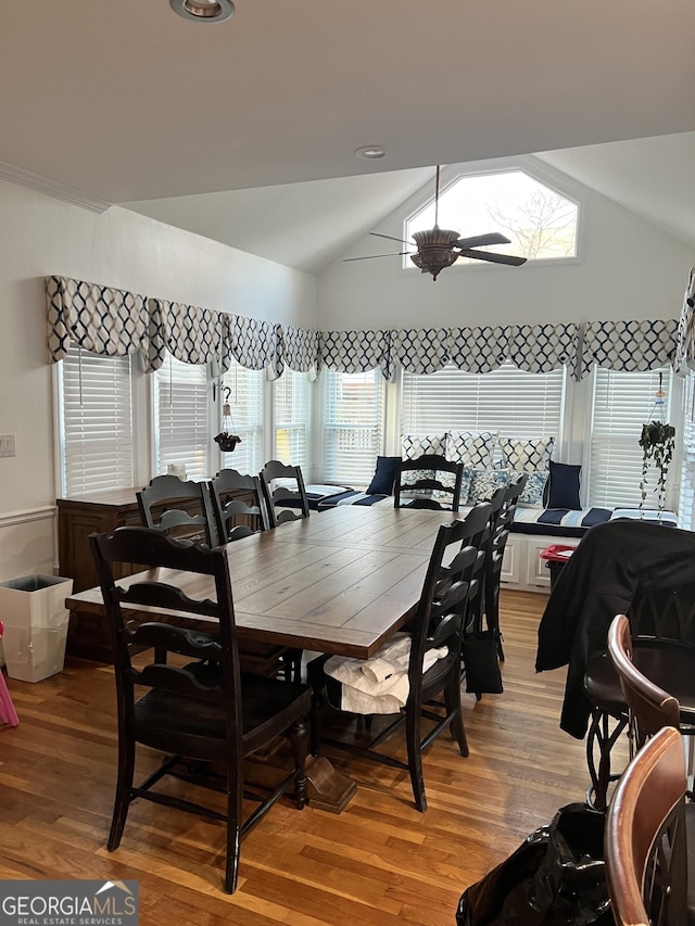 dining area featuring hardwood / wood-style flooring, ceiling fan, and vaulted ceiling