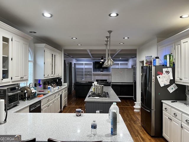 kitchen with hanging light fixtures, white cabinets, stainless steel appliances, and a kitchen island