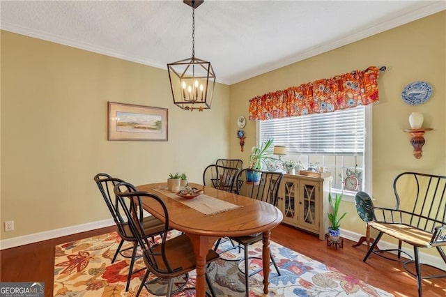 dining space featuring ornamental molding, a chandelier, and hardwood / wood-style flooring