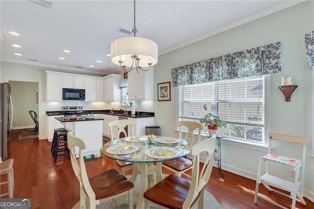 dining area featuring sink, dark hardwood / wood-style floors, and crown molding