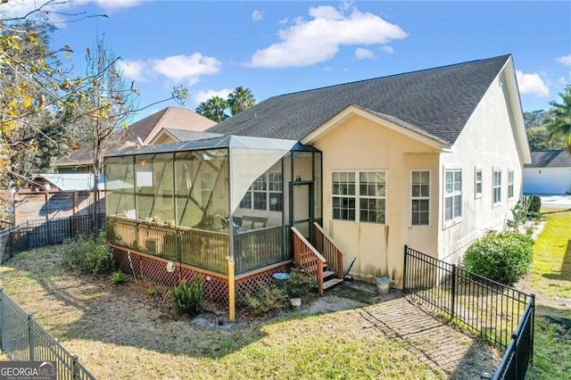 rear view of house featuring glass enclosure