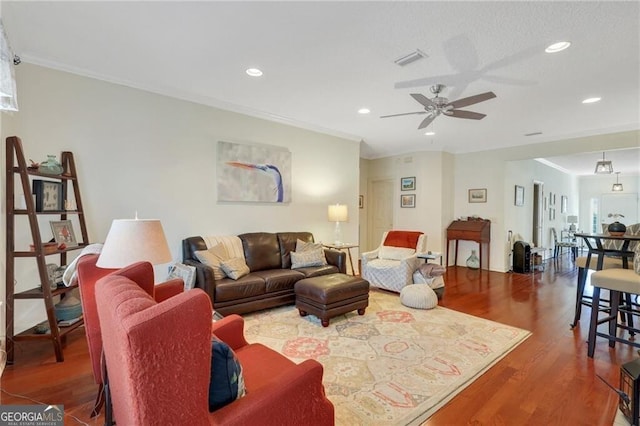 living room featuring ceiling fan, ornamental molding, and hardwood / wood-style floors