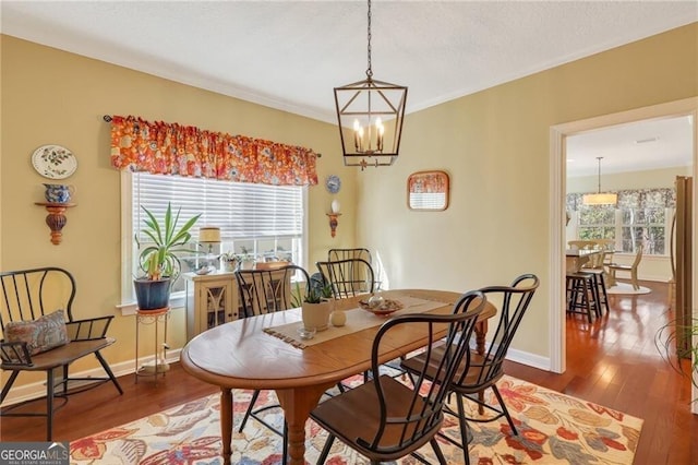 dining area featuring a wealth of natural light, hardwood / wood-style flooring, and a notable chandelier