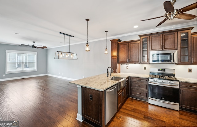 kitchen featuring sink, decorative light fixtures, ornamental molding, kitchen peninsula, and stainless steel appliances