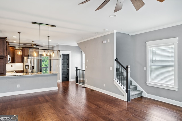 kitchen featuring light stone counters, crown molding, decorative light fixtures, stainless steel fridge with ice dispenser, and dark hardwood / wood-style floors