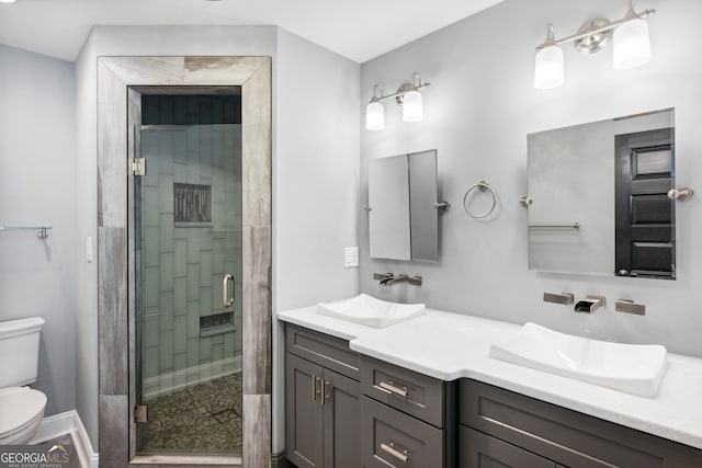 bathroom with vanity, a shower with shower door, and toilet