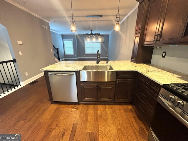 kitchen featuring sink, crown molding, hanging light fixtures, and appliances with stainless steel finishes