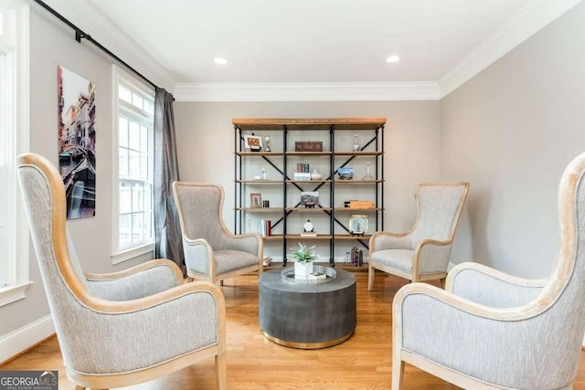 sitting room with plenty of natural light, crown molding, and hardwood / wood-style flooring