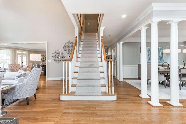 stairs with crown molding and wood-type flooring