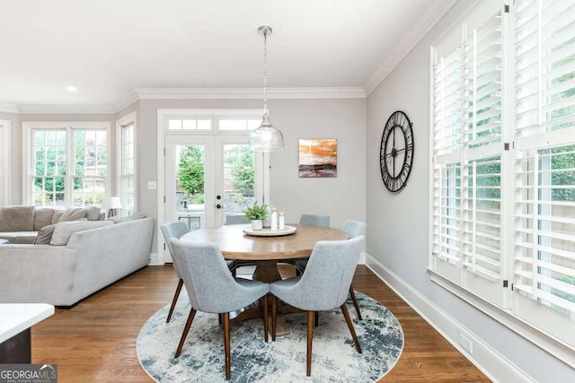 dining area featuring hardwood / wood-style floors, crown molding, and french doors