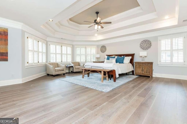 bedroom with a raised ceiling, ceiling fan, ornamental molding, and hardwood / wood-style floors