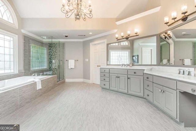 bathroom with a wealth of natural light, vanity, a notable chandelier, and plus walk in shower