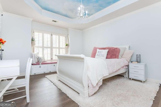 bedroom with crown molding, dark hardwood / wood-style floors, a tray ceiling, and a notable chandelier