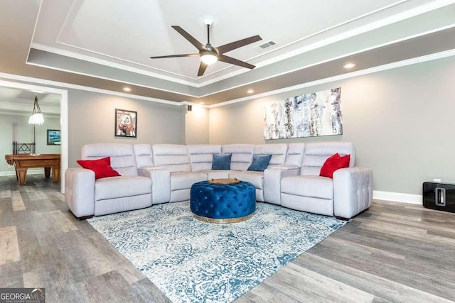 living room with hardwood / wood-style flooring, crown molding, a raised ceiling, and billiards