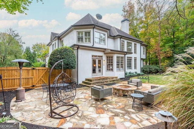 back of property featuring an outdoor living space with a fire pit and a patio