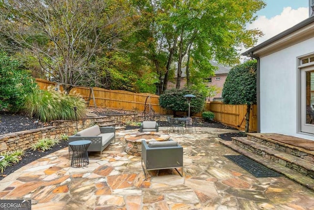 view of patio featuring an outdoor living space with a fire pit