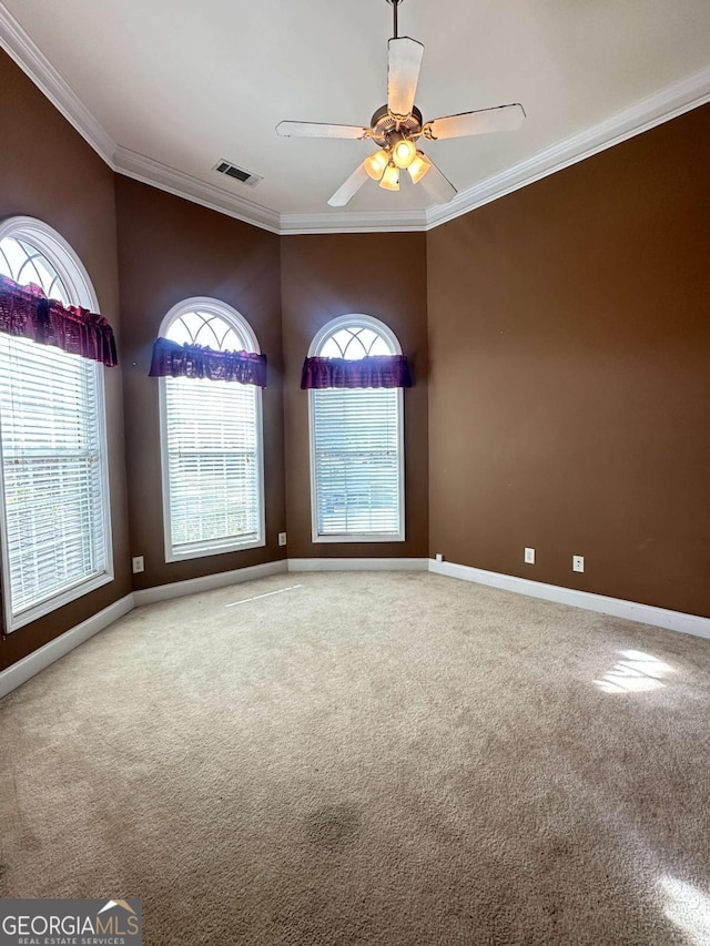 carpeted spare room featuring ceiling fan and ornamental molding