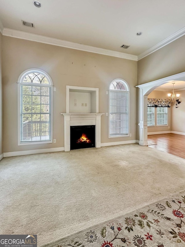 unfurnished living room with carpet floors, crown molding, and a chandelier