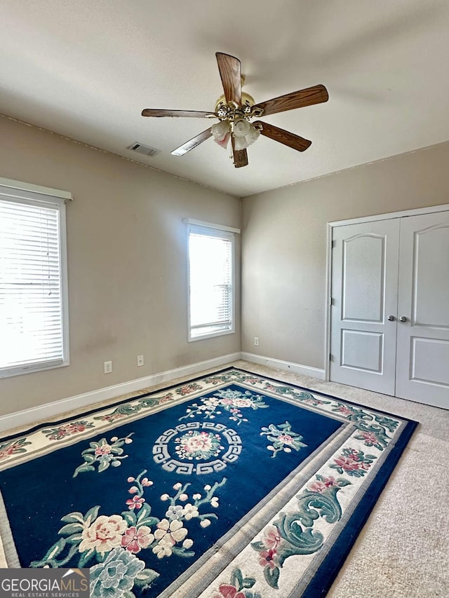 carpeted spare room with ceiling fan