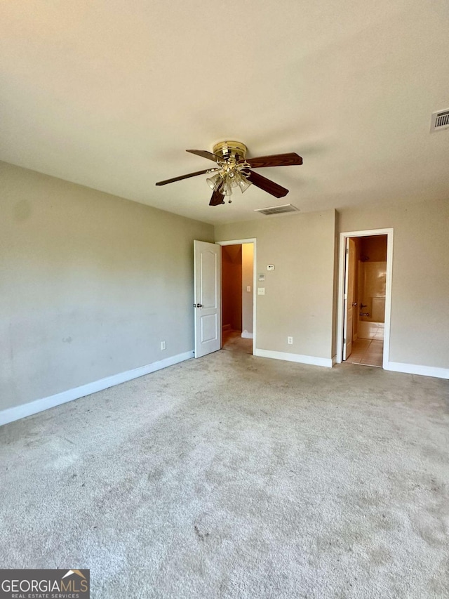 carpeted spare room featuring ceiling fan