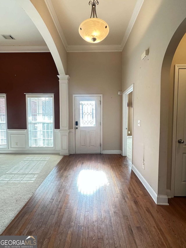 entryway featuring a high ceiling, dark hardwood / wood-style floors, and ornamental molding