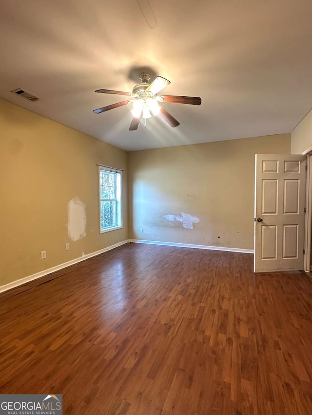 unfurnished room with ceiling fan and dark hardwood / wood-style floors