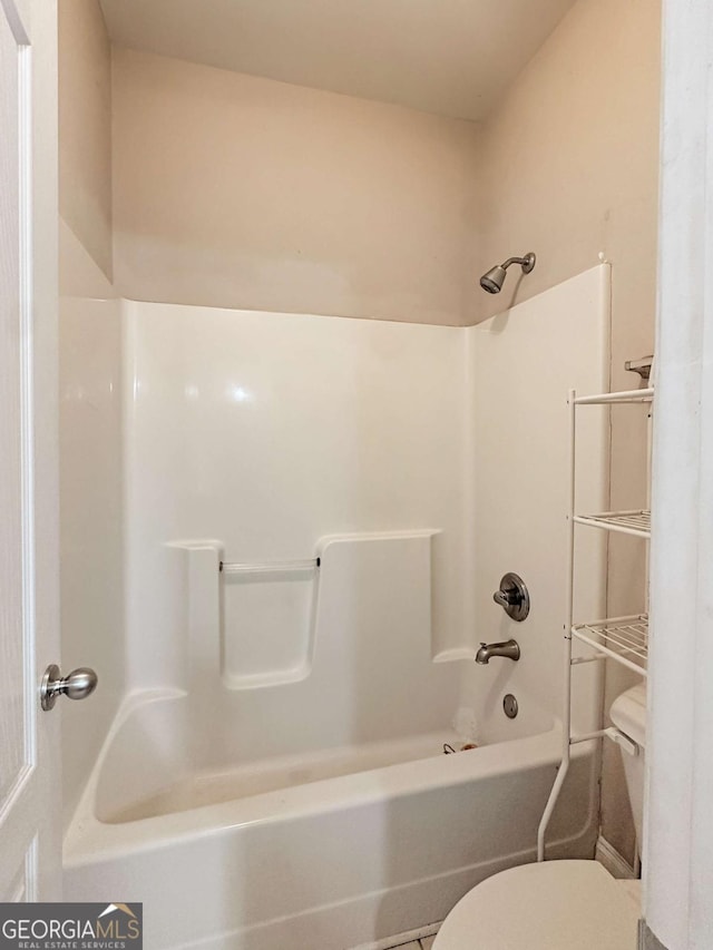 bathroom with toilet, tile patterned flooring, and bathing tub / shower combination