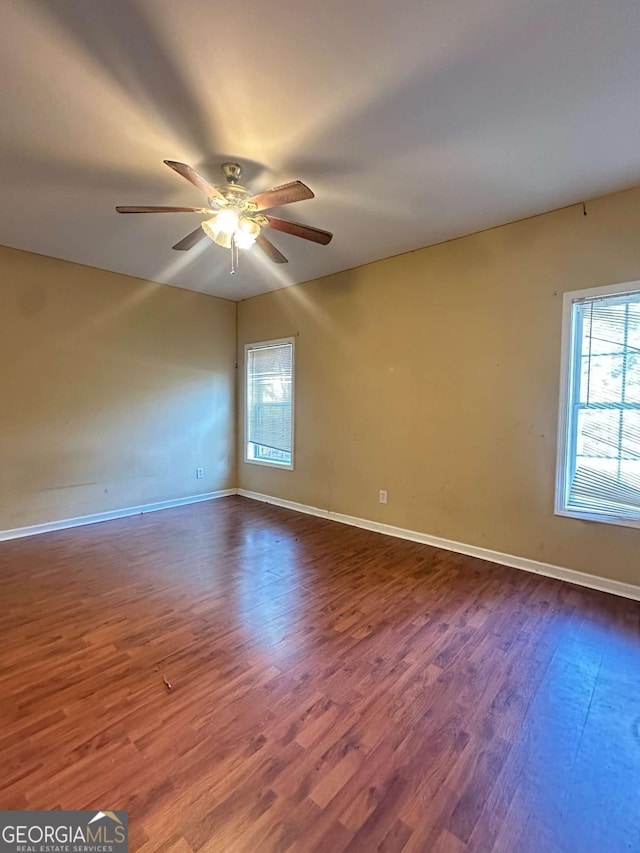 empty room featuring ceiling fan, a wealth of natural light, and hardwood / wood-style flooring