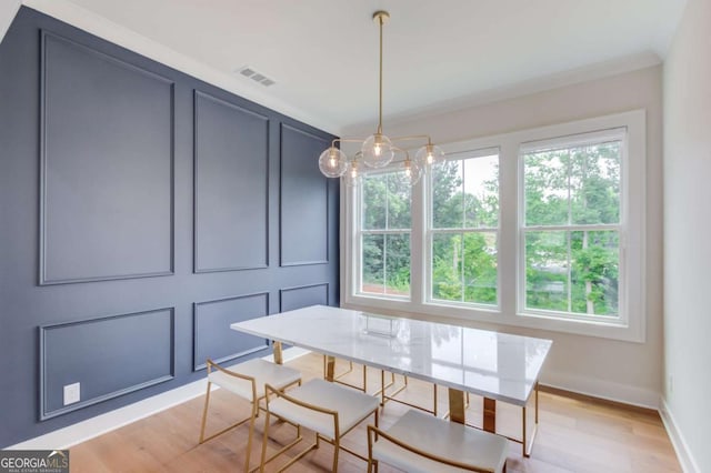 dining area featuring light hardwood / wood-style flooring and ornamental molding