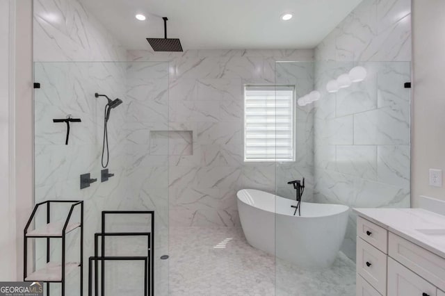 bathroom featuring separate shower and tub, vanity, and tile walls