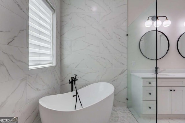 bathroom featuring vanity, a healthy amount of sunlight, a tub, and tile walls