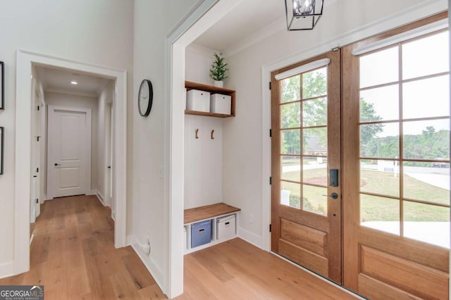 mudroom featuring a notable chandelier, french doors, and light wood-type flooring