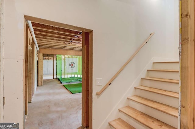 stairs featuring concrete flooring