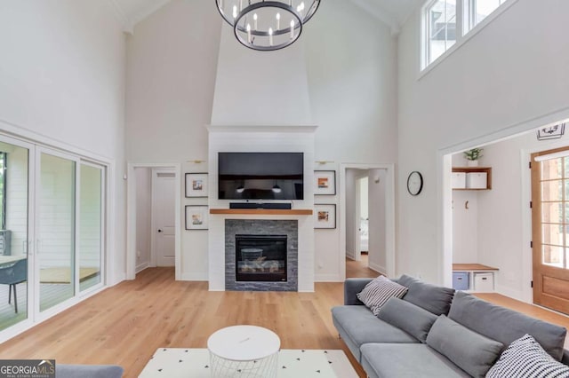 living room featuring plenty of natural light, a high ceiling, and light hardwood / wood-style floors