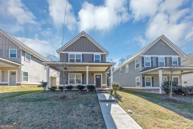 view of front of home with covered porch and a front lawn