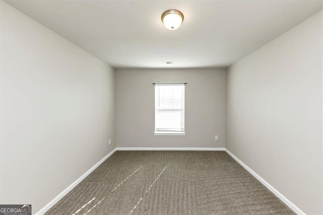 spare room with dark carpet