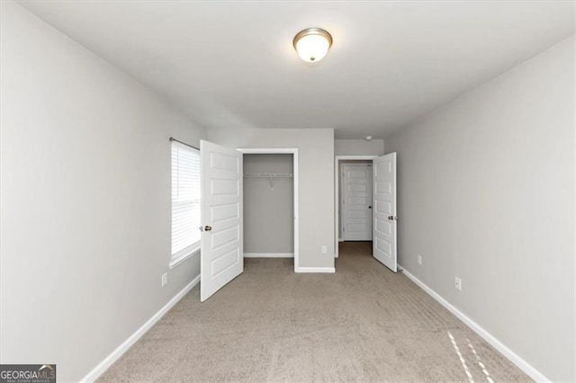 unfurnished bedroom featuring light carpet and a closet