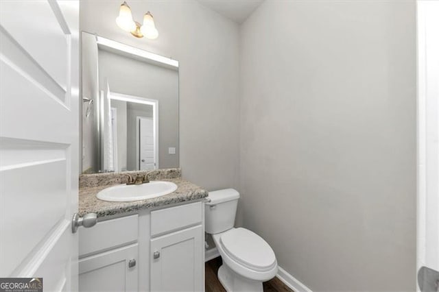 bathroom featuring hardwood / wood-style flooring, vanity, and toilet