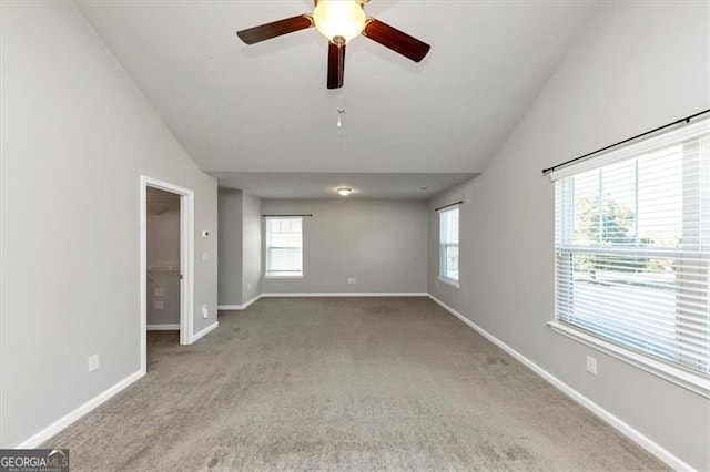 unfurnished room with ceiling fan, a healthy amount of sunlight, light colored carpet, and high vaulted ceiling