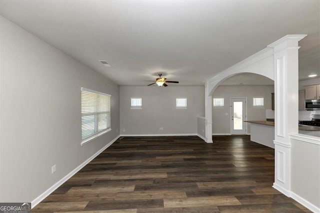 unfurnished living room featuring dark wood-type flooring and ceiling fan