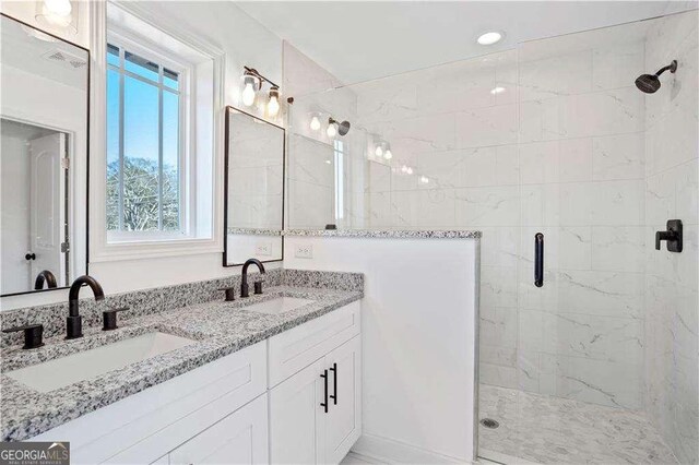 bathroom with a shower with shower door and vanity