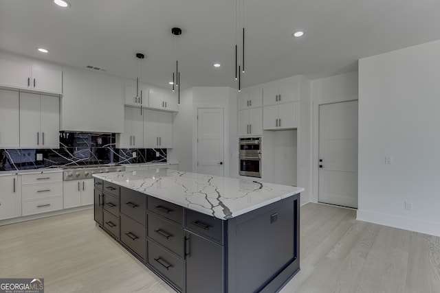 kitchen featuring light hardwood / wood-style floors, backsplash, decorative light fixtures, white cabinets, and a center island