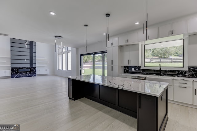 kitchen with backsplash, pendant lighting, white cabinets, and a center island