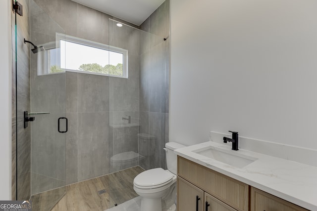 bathroom featuring an enclosed shower, vanity, toilet, and hardwood / wood-style floors