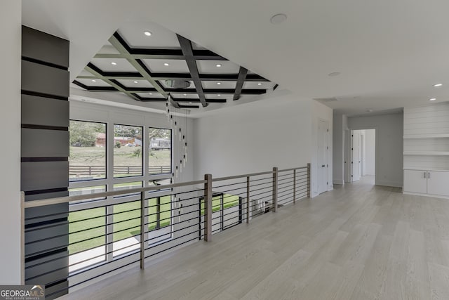 hallway featuring light wood-type flooring, coffered ceiling, and beamed ceiling