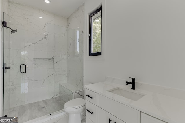 bathroom featuring toilet, a shower with shower door, and vanity