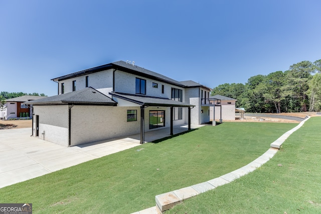 back of house featuring a lawn and a patio