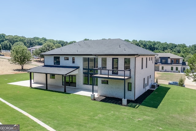 rear view of house featuring central AC unit, a lawn, a balcony, and a patio